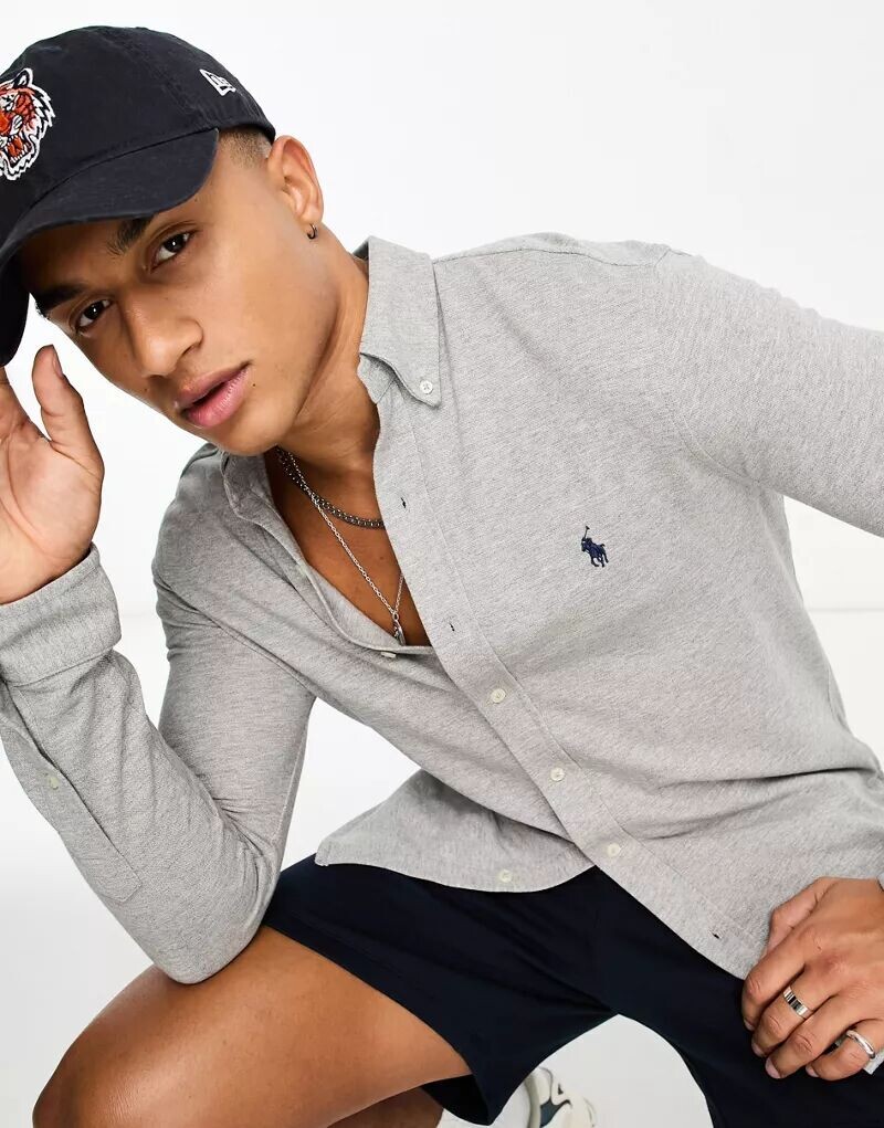 Пятнистая серая рубашка из пике Polo Ralph Lauren с воротником на пуговицах и логотипом бренда
Пятнистая серая рубашка из пике Polo Ralph Lauren с воротником на пуговицах и логотипом бренда