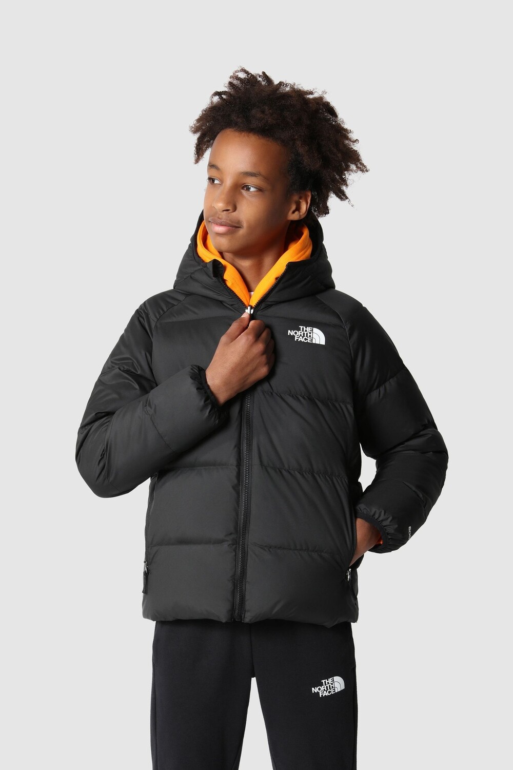 

Двусторонний пуховик для мальчика черного цвета с капюшоном и принтом The North Face, черный