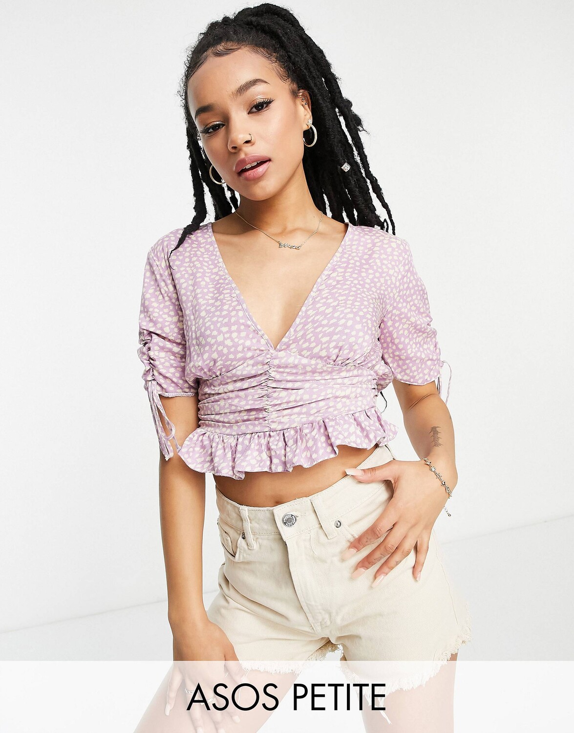 

Сиреневая блуза с цветочным принтом ASOS DESIGN Petite с v-образным вырезом, рюшами на талии и подолом с баской