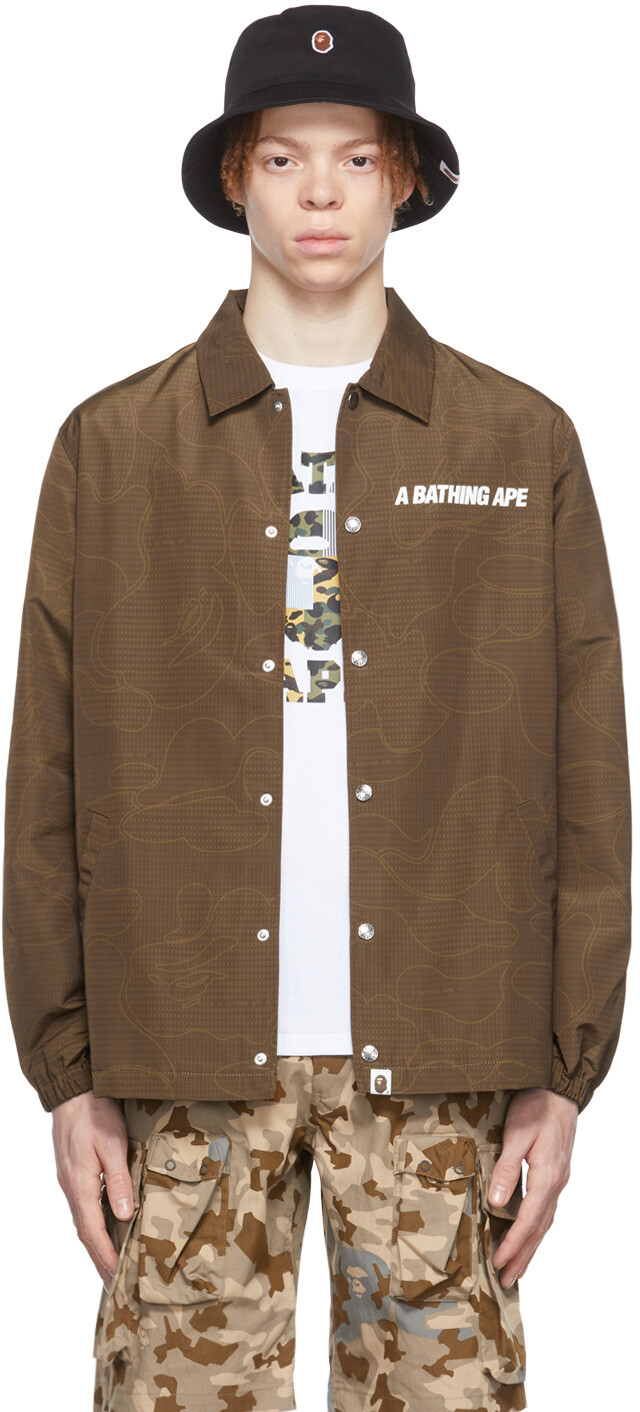 

Коричневая спортивная куртка с камуфляжным текстом и кодом BAPE