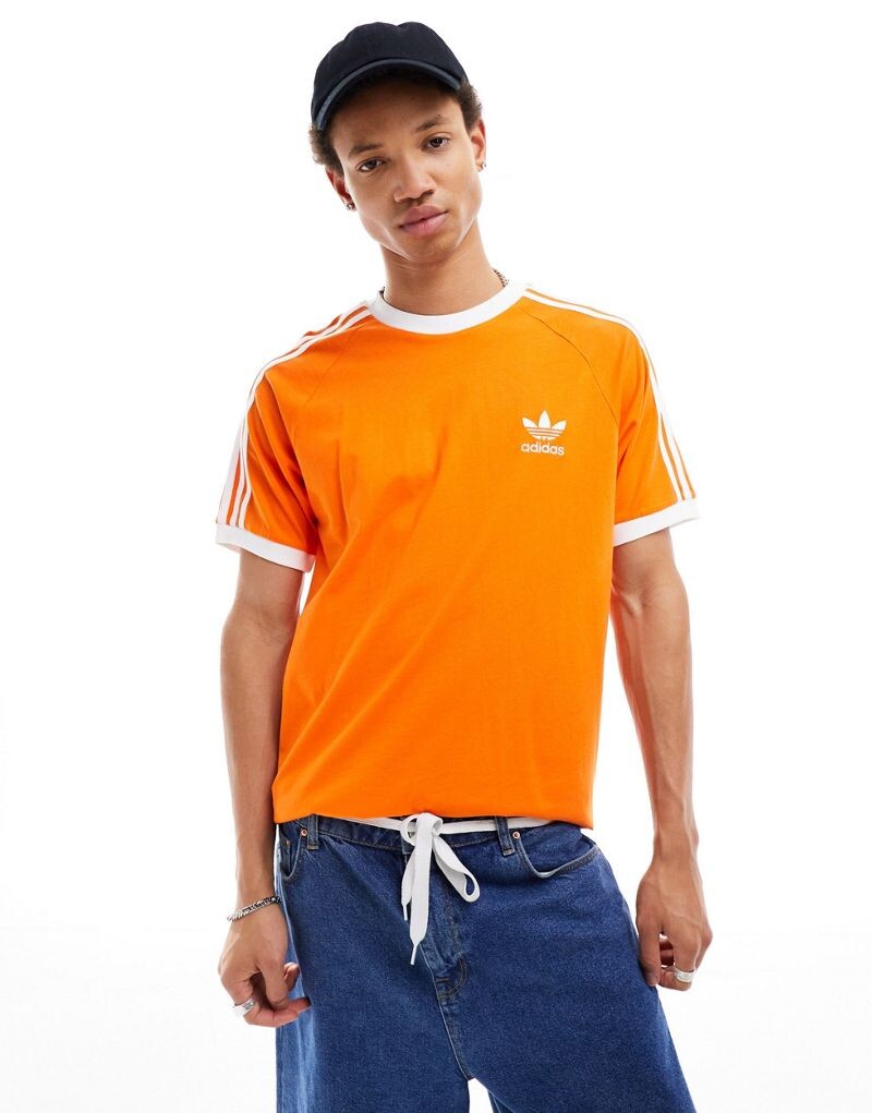 

Оранжевая футболка с тремя полосками adidas