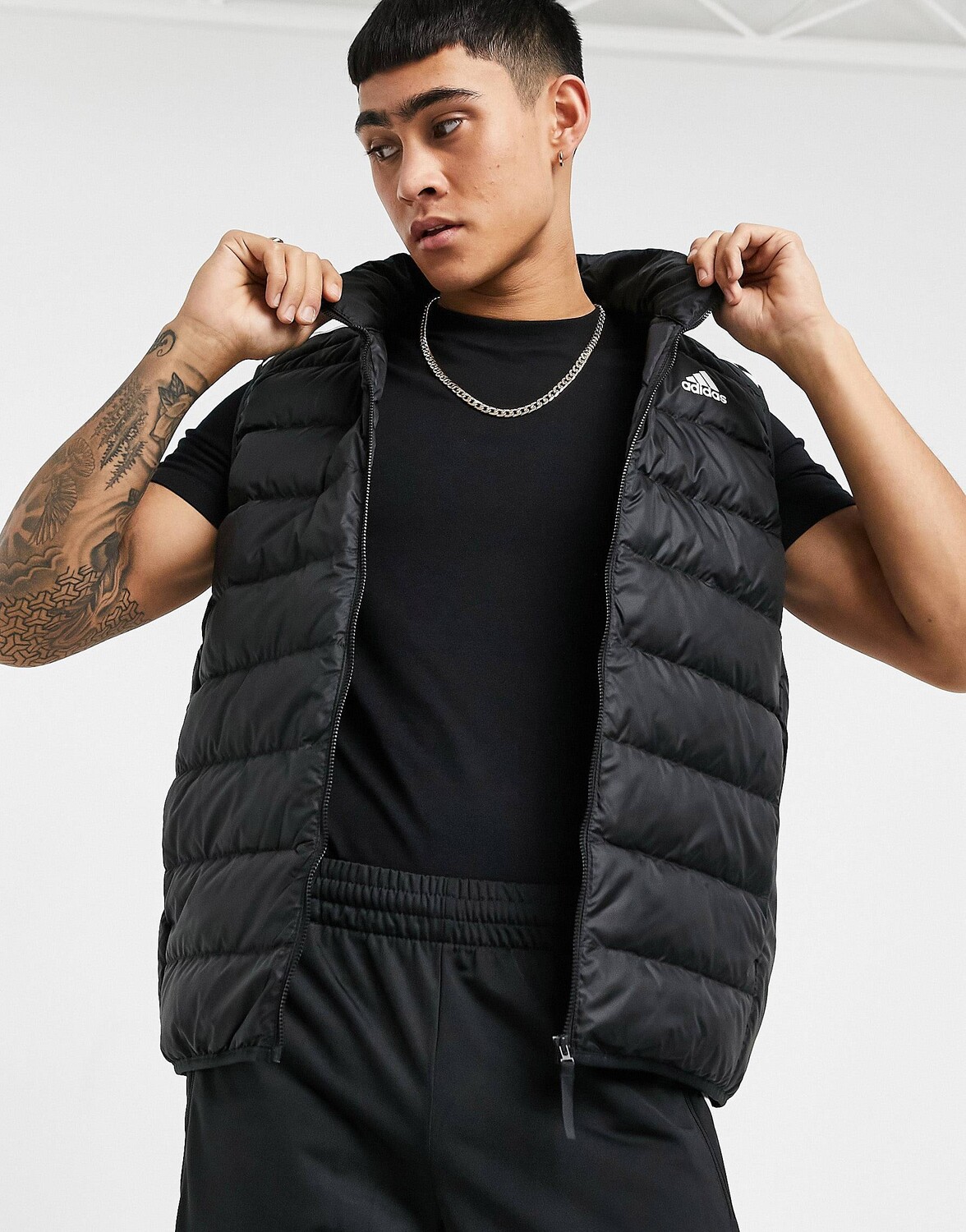 

Черный пуховик с тремя полосками adidas Outdoor