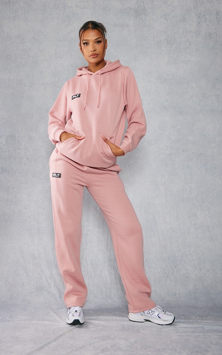 

PrettyLittleThing Бледно-розовые прямые джоггеры с логотипом и значком