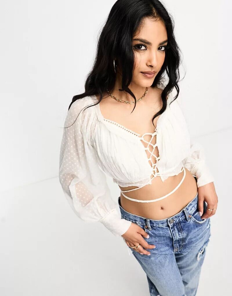 

ASOS — укороченный топ цвета слоновой кости с длинными рукавами, завязками спереди, рюшами и рюшами