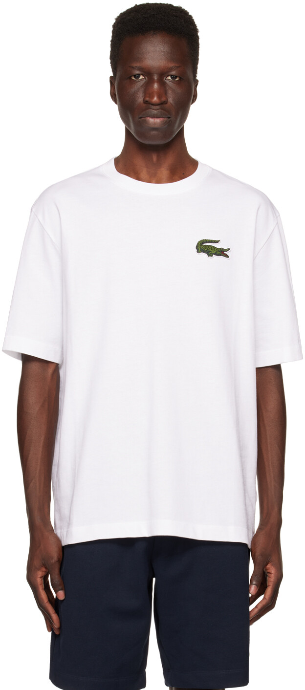 

Белая футболка с нашивками Lacoste