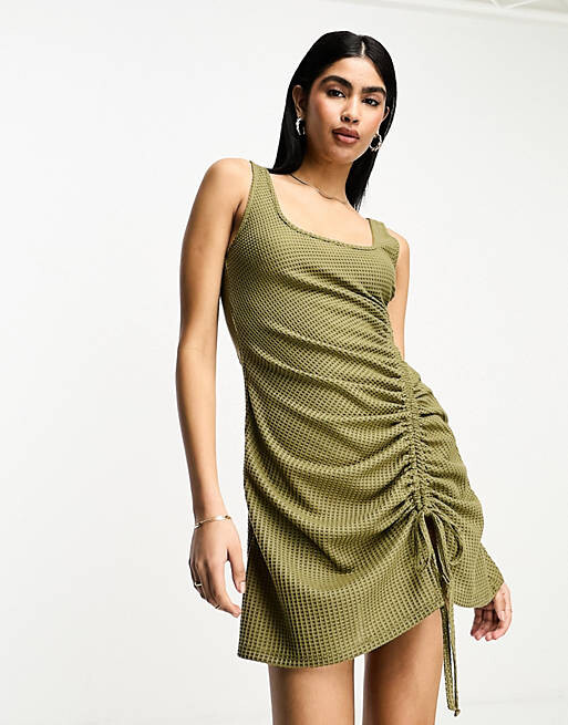

Вафельное платье цвета хаки со сборками и овальным вырезом по бокам ASOS DESIGN