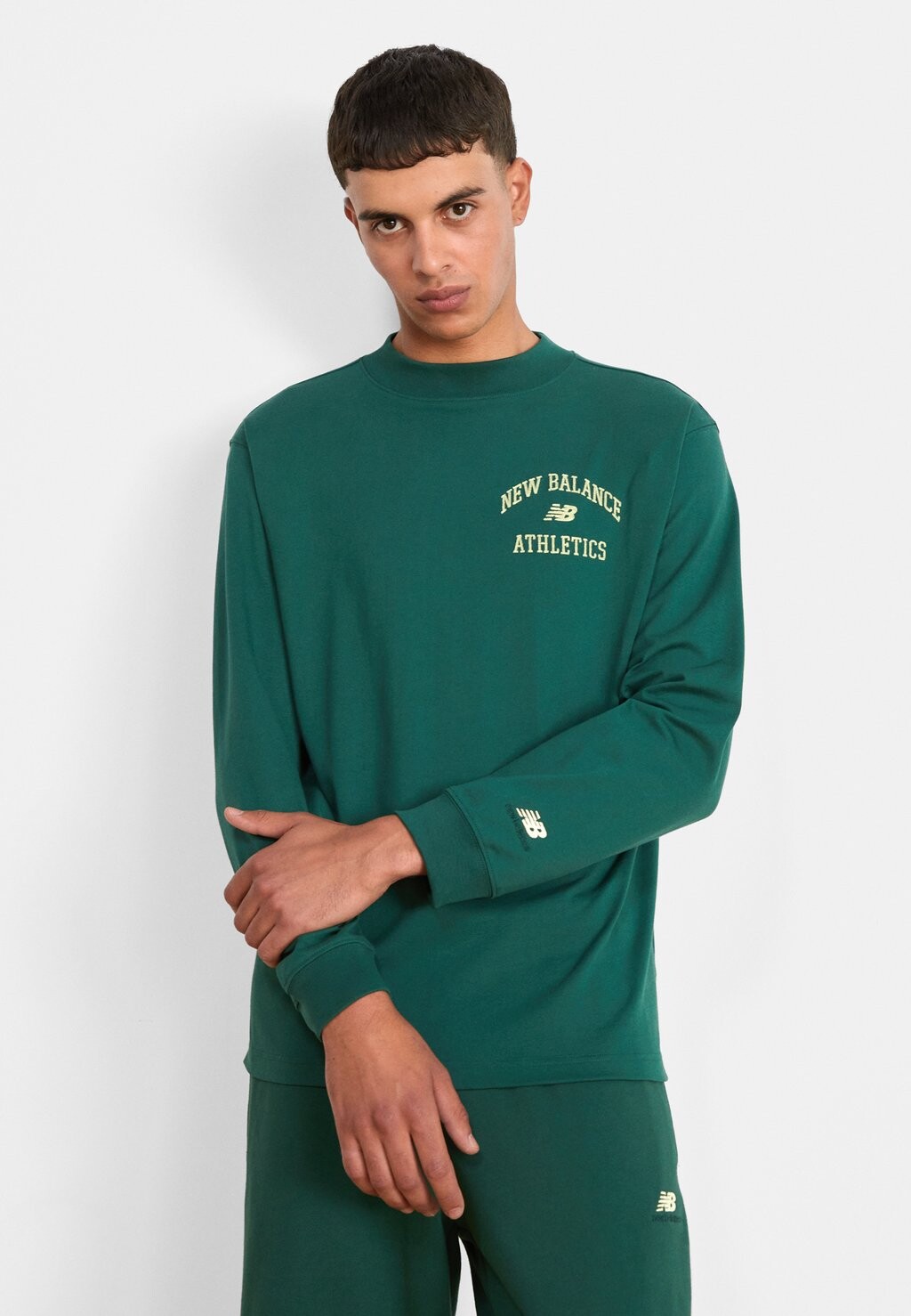 

Футболка с длинными рукавами ATHLETICS VARSITY GRAPHIC MOCK LONGSLEEVE New Balance, ночные часы, зеленый