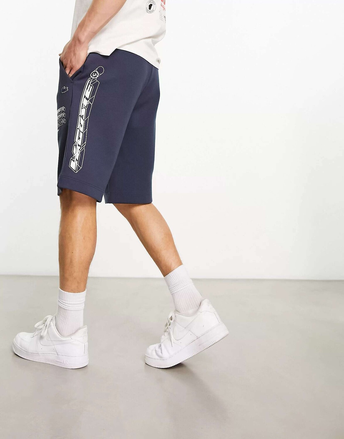 

Темно-синие шорты с крупным логотипом и горизонтальным брендингом Lacoste