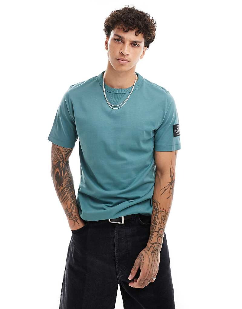 

Бирюзовая футболка с нашивками Calvin Klein Jeans