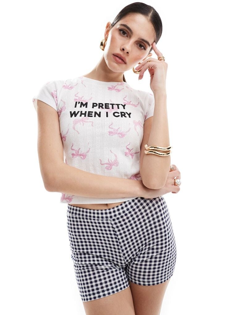 ASOS DESIGN — Короткая облегающая ажурная футболка с надписью и бантом по всей поверхности