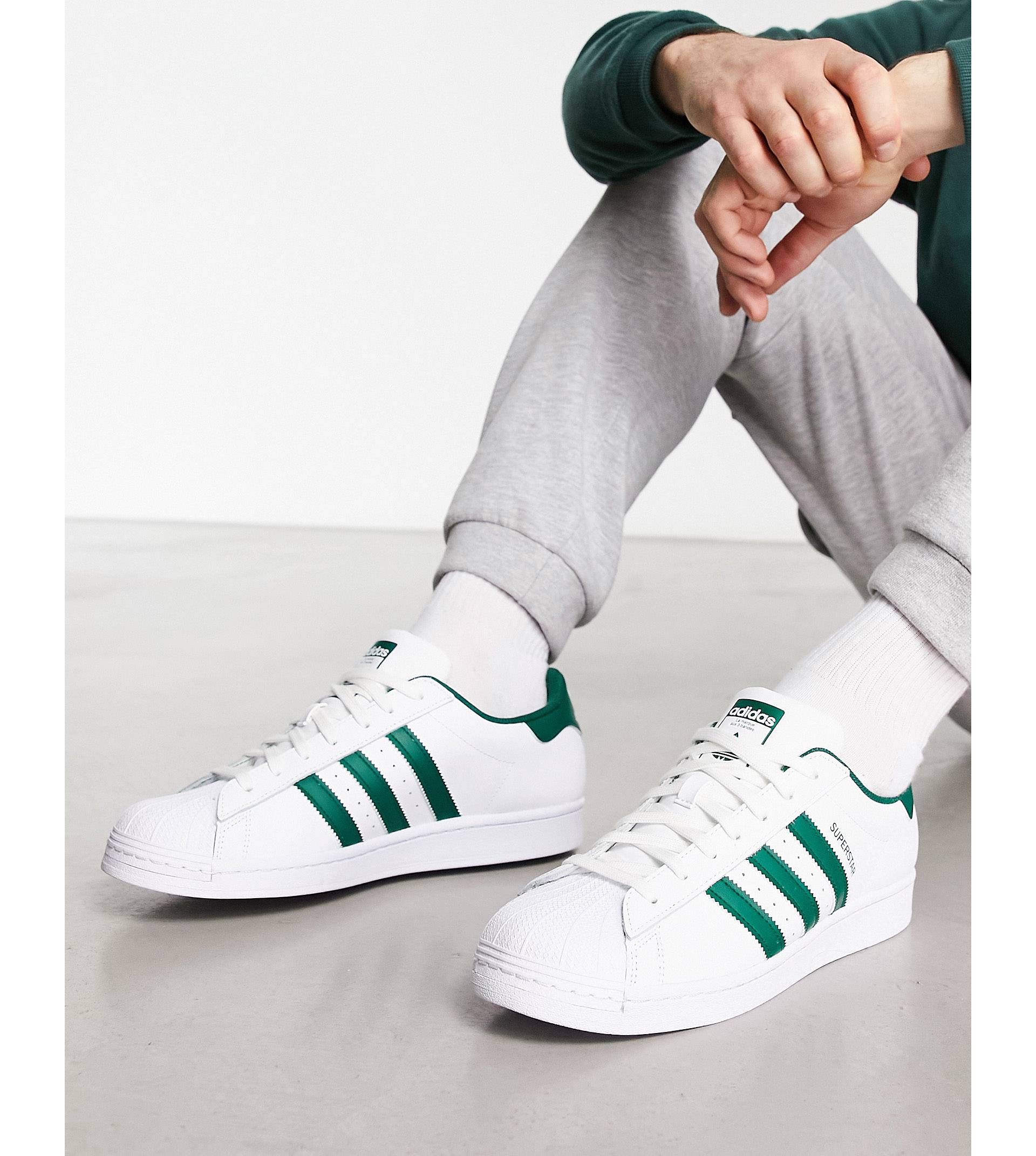 цена Бело-зеленые кроссовки adidas Originals Superstar