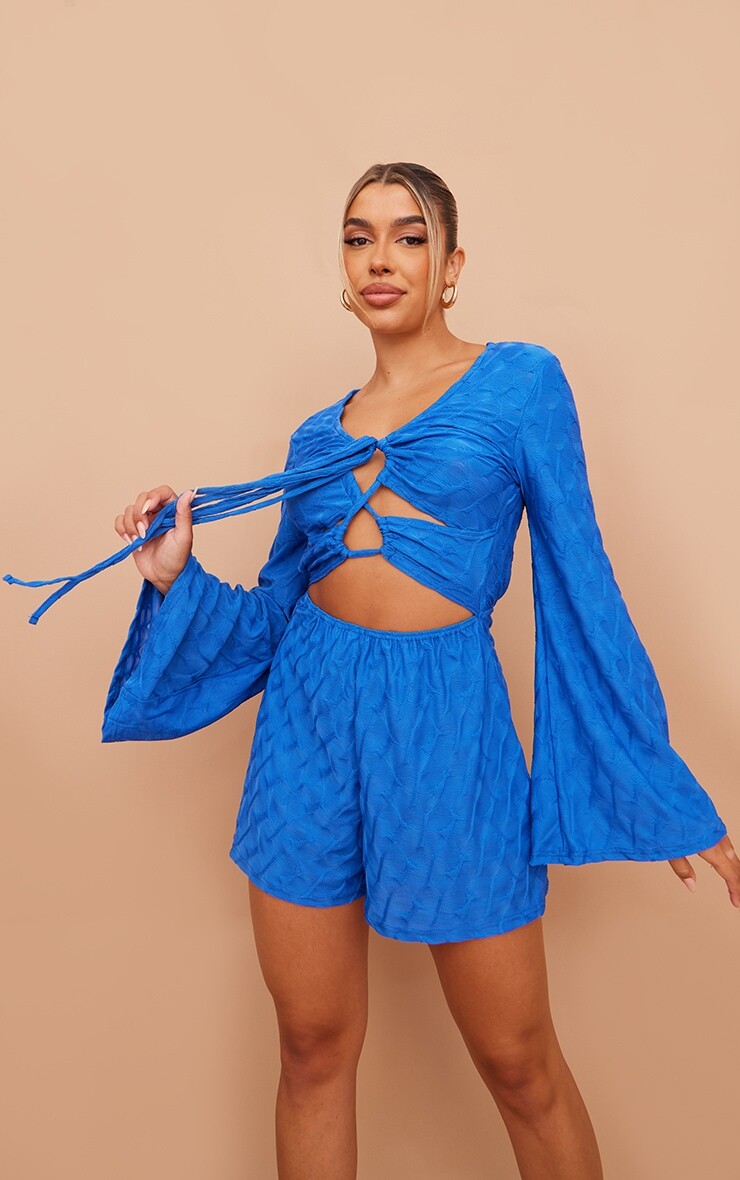 

PrettyLittleThing Ярко-синий фактурный комбинезон на шнуровке с расклешенными рукавами