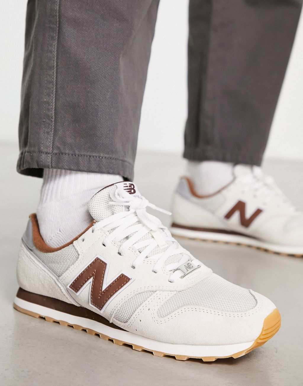 

Кроссовки New Balance 373 кремово-белого и коричневого цветов.