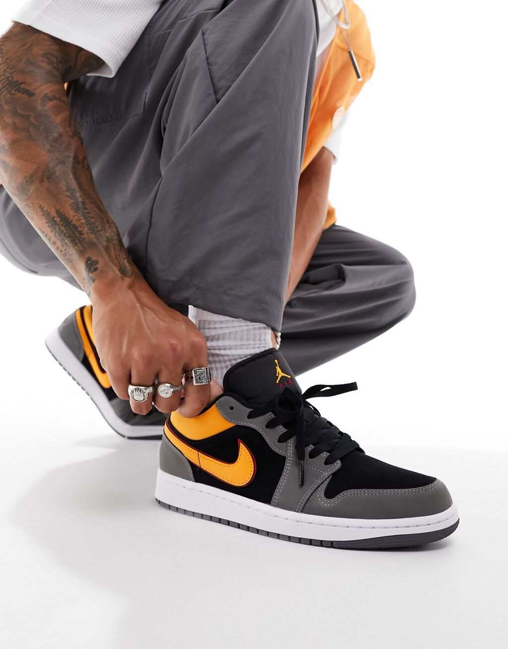 

Кроссовки Air Jordan 1 Low ярко-оранжевого, серого и черного цветов.