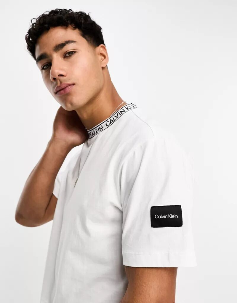 

Белая футболка Calvin Klein с окантовкой логотипа на вырезе и нашивкой сбоку