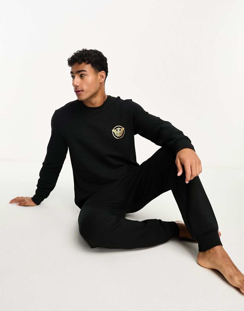 

Черный спортивный костюм и спортивные штаны Emporio Armani Bodywear с золотым логотипом