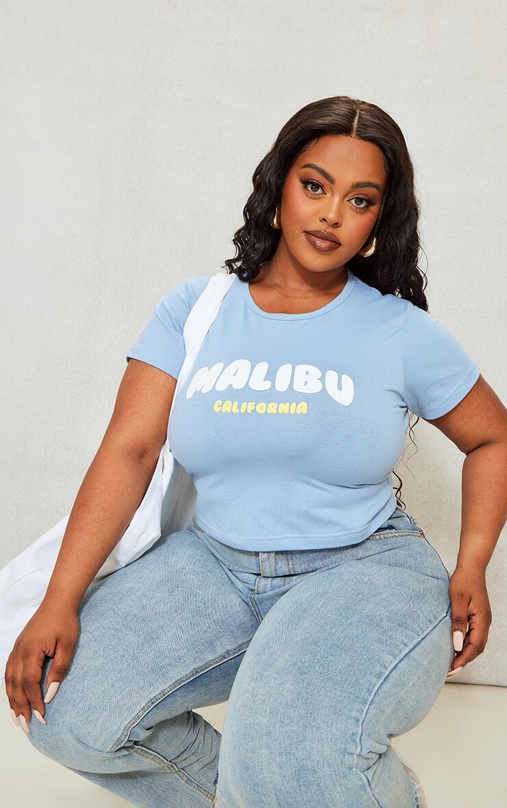 

PrettyLittleThing Синяя укороченная футболка с принтом Plus Malibu Puff