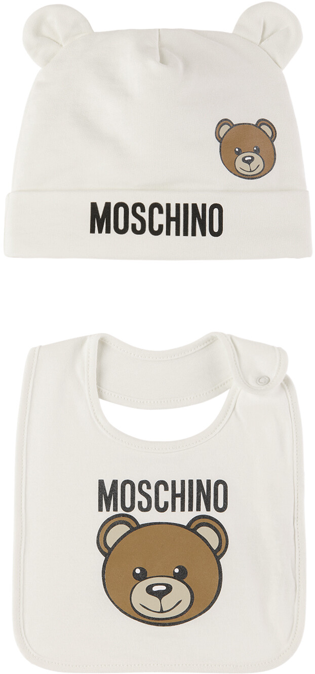 

Белый комплект из шапочки и нагрудника с принтом для малышей Moschino