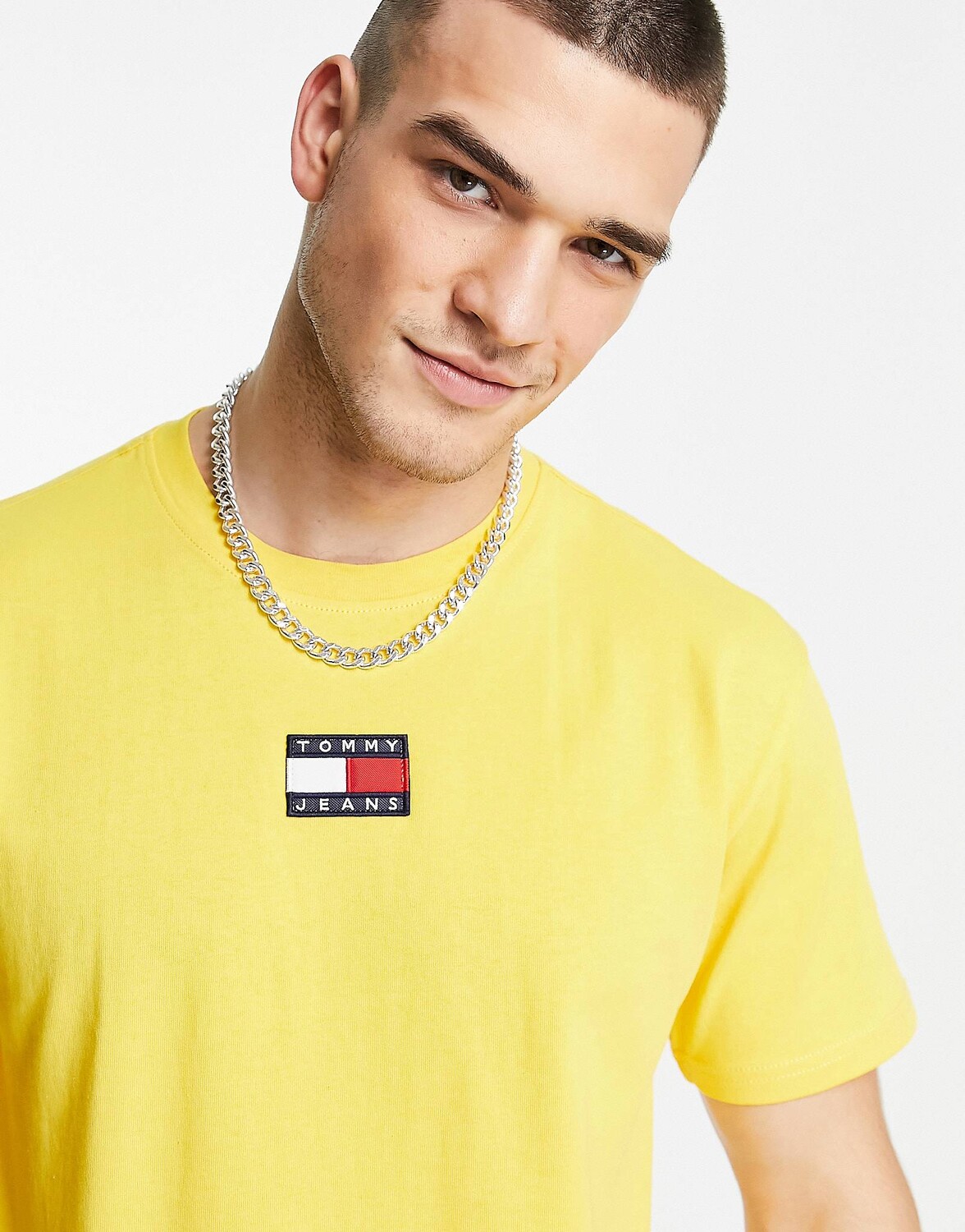 

Желтая футболка с центральным значком и логотипом Tommy Jeans