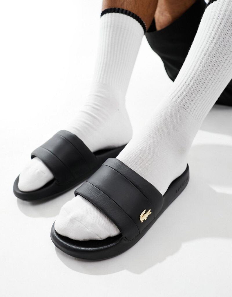 

Черные шлепанцы с золотыми булавками Lacoste Serve