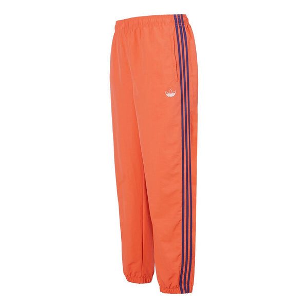 

Спортивные штаны adidas originals Woven Three Stripe Warm up Pants, оранжевый