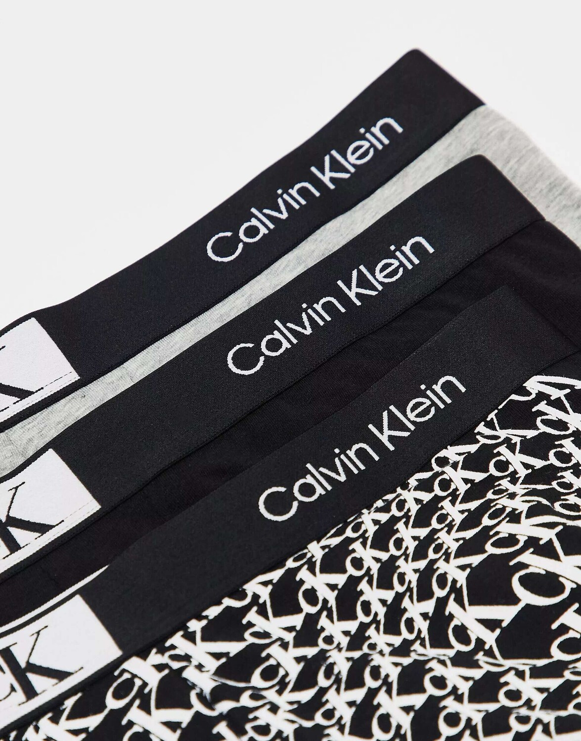 

Три пары плавок Calvin Klein CK 96 черного, черного и серого цвета с принтом